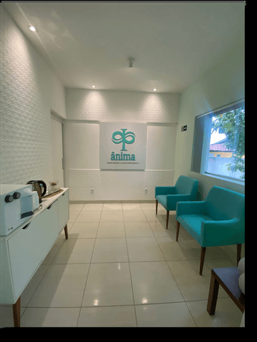Sala de espera com poltronas verdes e o logo Ânima
